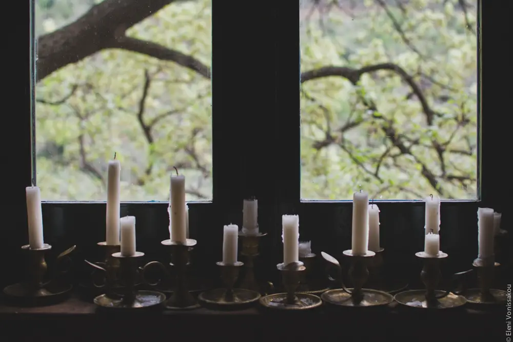 Milia Workshop 2017 – A long overdue recap. Part 1. www.thefoodiecorner.gr - Photo description: Old fashioned candlesticks with handles sitting in a row on a windowsill. The white candles are half burnt. Behind them the branches of a tree are visible through the window.