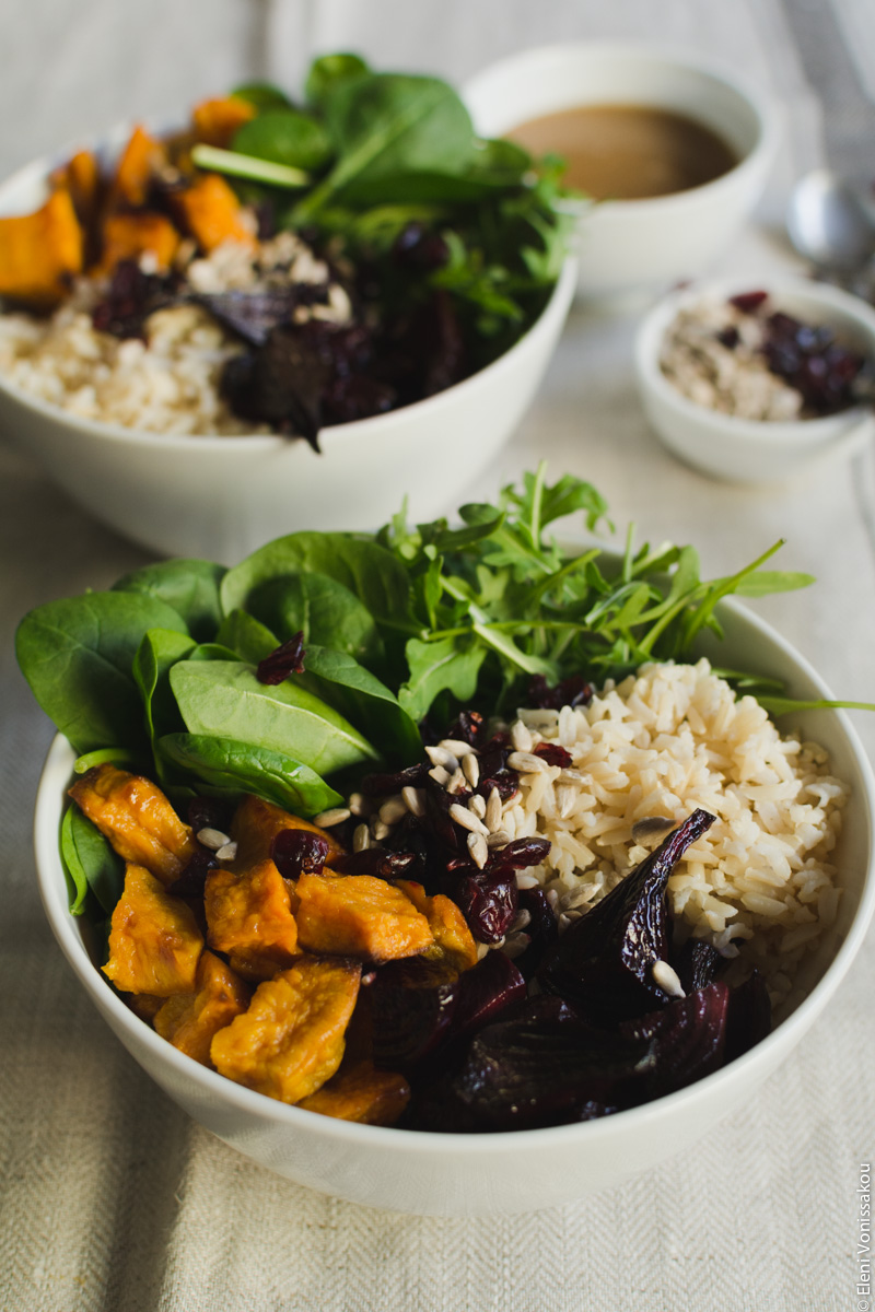 Roast Beetroot and Sweet Potato Buddha Bowl with Spicy Tahini Honey Dressing www.thefoodiecorner.gr  Photo description: A close up ¾ view of the one bowl and its contents. In the background the other bowl and the two small bowls with dressing and sunflower seeds.