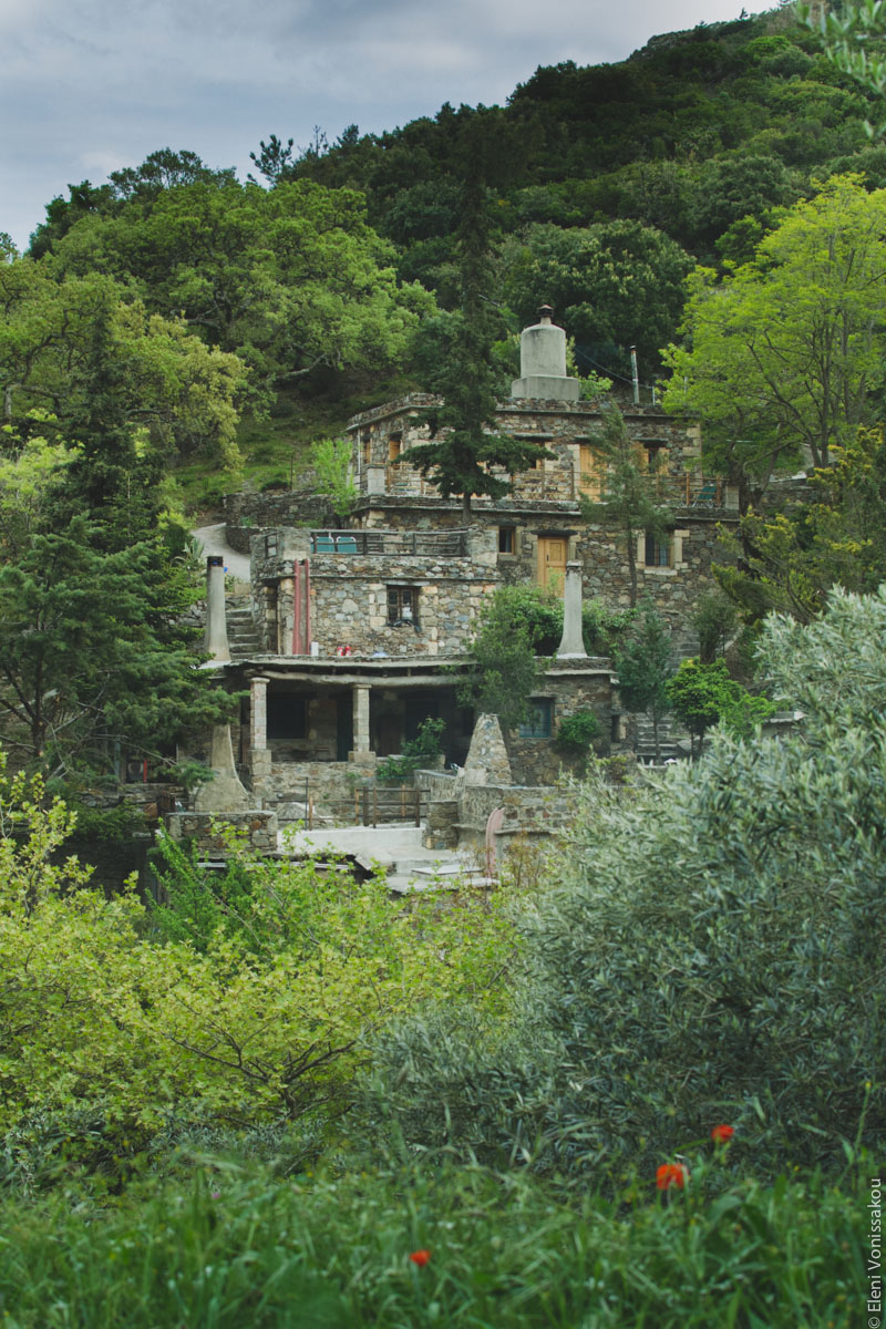 Miliaworkshop2017 www.thefoodiecorner.gr Photo description: Stone buildings visible from afar, set amongst lush green trees and bushes