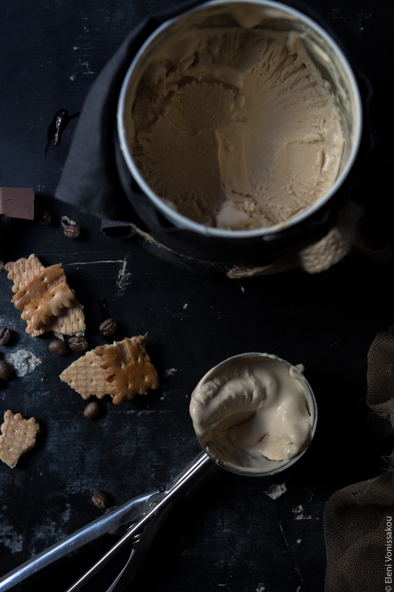 Olive Oil Brownie and No-Churn Coffee Mascarpone Ice Cream Sundae www.thefoodiecorner.gr Photo description: A top view of the full tub of ice cream (to the top of the photo) and the ice cream scoop with some of the ice cream in it (to the bottom). On the left some of the broken biscuits soaked in liqueur.