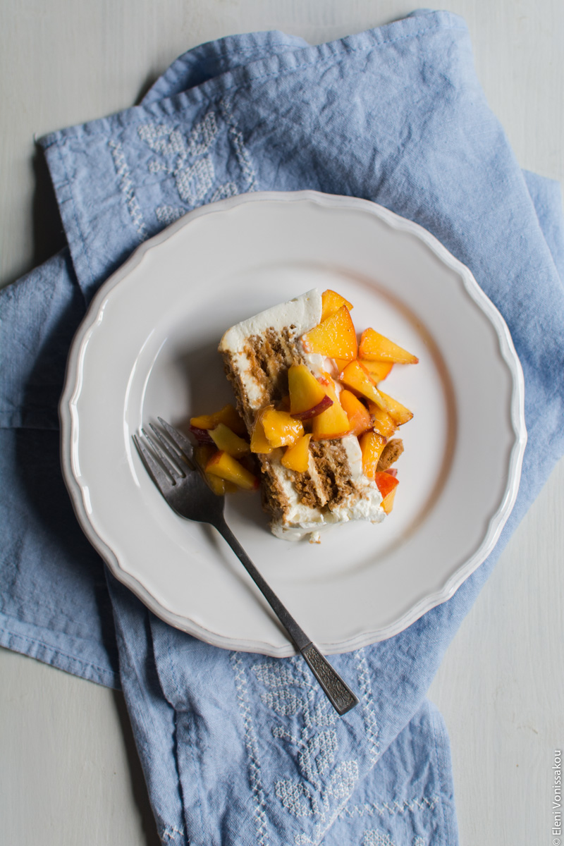 Greek Yoghurt, Mascarpone and Speculoos (Biscoff) Cookie Fridge Cake with Peaches www.thefoodiecorner.gr Photo description: Another shot of the slice of cake on the plate, from further above.