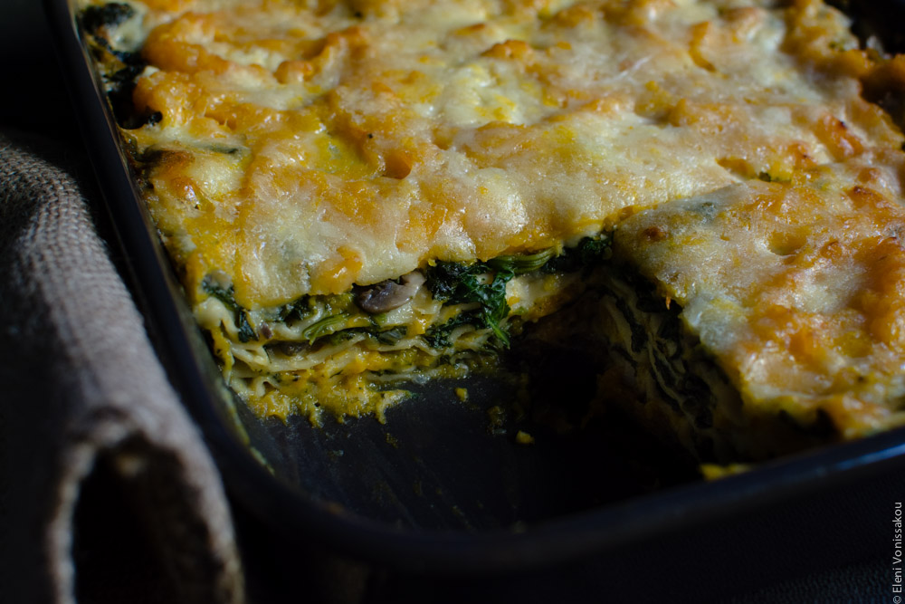 Cottage Cheese Vegetable Lasagne with Butternut Squash, Spinach and Mushrooms www.thefoodiecorner.gr Photo description: A close view of the cooked lasagna in the dish with a piece missing, thus making the inside layers visible.