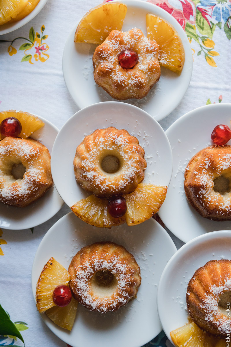 Greek Ravani Turned Mini Pina Colada Cakes www.thefoodiecorner.gr Photo description: The plates all placed closely together, with a few stacked on top of others, offering a close view of the cakes.