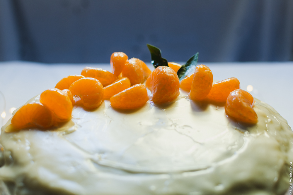 Greek New Year’s Cake (Vassilopita) with Mandarin, Almonds and Cardamom www.thefoodiecorner.gr Photo description: A closer, backlit view of the top of the cake and the mandarin segments.