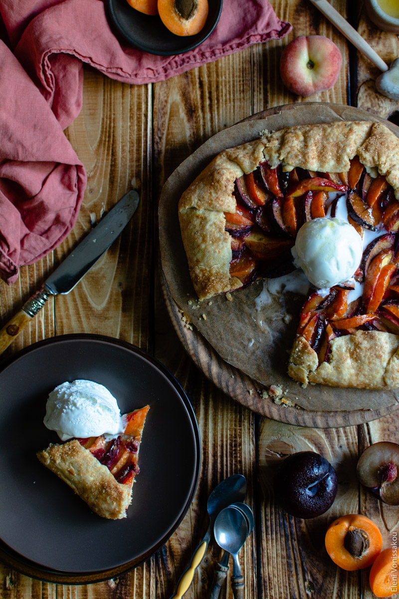 Easy Anthotyro Galette with Spiced Summer Fruit www.thefoodiecorner.gr Photo description: Similar set up to main photo, but the one slice has been transferred to the top plate in the bottom left corner. A scoop of ice cream sits next to the slice. The ice cream on the galette has started to melt into the fruit.