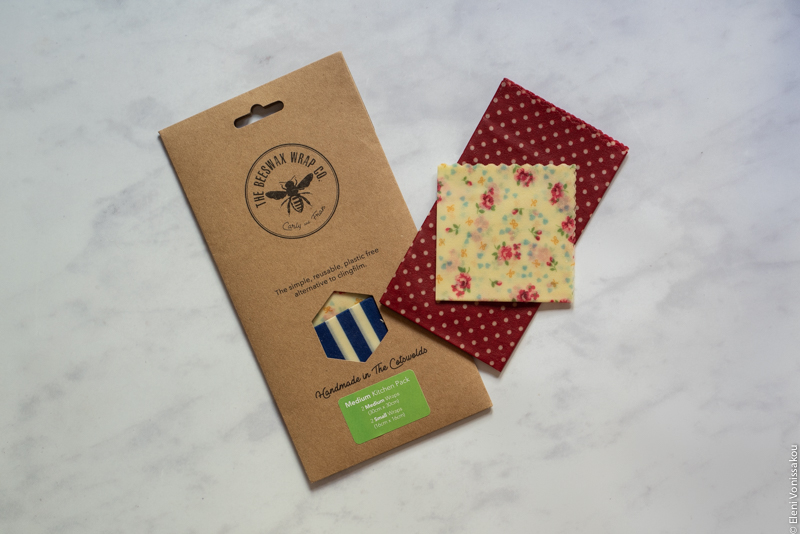 A packet of beeswax wraps and two more wraps lying on a marble surface.