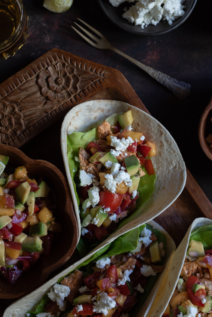 Spicy Salmon Tacos with Manouri Cheese and Peach Avocado Salsa www.thefoodiecorner.gr Photo description: A close up of one of the tacos on the wooden tray.