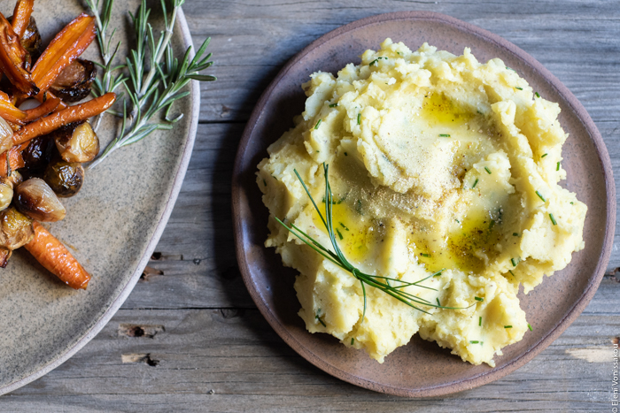 Dairy Free Garlic Mashed Potatoes with Olive Oil and a Hint of Truffle www.thefoodiecorner.gr Photo description: A close view of mashed potatoes on a ceramic plate. The top is uneven, with pools of olive oil here and there, and a small bunch of chives arranged at the side.