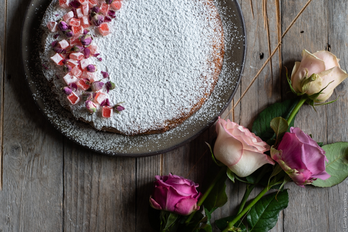 Almond Cardamom Rose Cake with Semolina and Olive Oil www.thefoodiecorner.gr Photo description: A closer view of the cake (half visible), next to which a some roses (half visible).