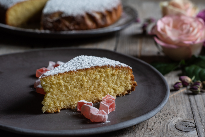 Almond Cardamom Rose Cake with Semolina and Olive Oil www.thefoodiecorner.gr Photo description: A side view of a slice of cake on a plate. Also on the plate are some small pieces of turkish delight.