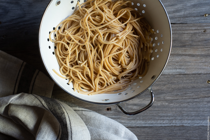 Quick and Easy Smoked Tuna Spaghetti with Parsley and Capers www.thefoodiecorner.gr Photo description: A close up of a colander full of cooked whole wheat spaghetti. To the bottom of the photo a bunched up linen tea towel.