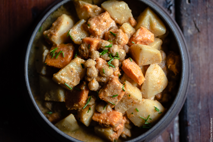 Slow Cooker Sweet Potato Chickpea Coconut Curry www.thefoodiecorner.gr Photo description: A close view of a sweet potato chickpea coconut curry in a large ceramic serving bowl. Some chopped chives decorate the top.