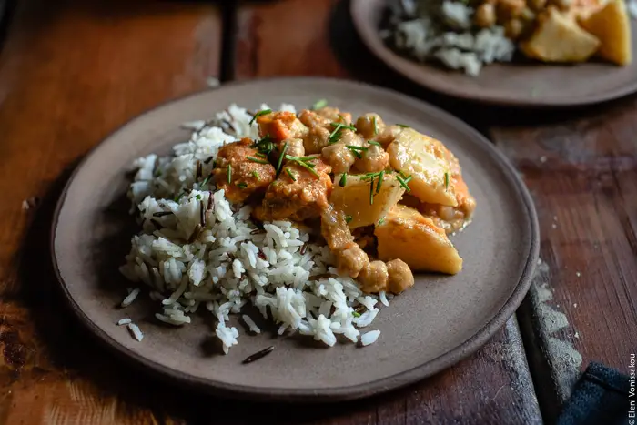 Slow Cooker Sweet Potato Chickpea Coconut Curry www.thefoodiecorner.gr Photo description: A ¾ view of a ceramic plate with a serving of basmati and wild rice, and curry on top.