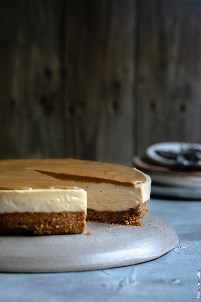 Easy Speculoos Cheesecake www.thefoodiecorner.gr Photo description: a side view of a speculoos cheesecake with one slice missing.