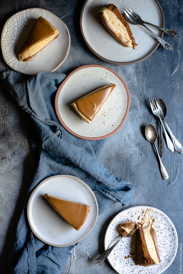 Εύκολο Τσίζκεϊκ με Άλειμμα Μπισκότου Speculoos (Χωρίς Ψήσιμο) www.thefoodiecorner.gr Photo description: five plates each with a slice of speculoos cheesecake. A couple of slices have fallen on their side and one plate has a spoon with a bite of cheesecake on it. Three of the plates are sitting on a bunched up linen tea towel.