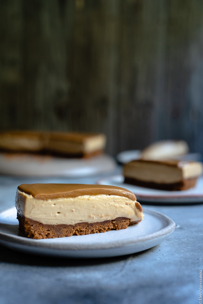 Easy Speculoos Cheesecake www.thefoodiecorner.gr Photo description: A side view of a slice of cheesecake, the three layers (biscuit base, creamy filling and melted speculoos) clearly visible.