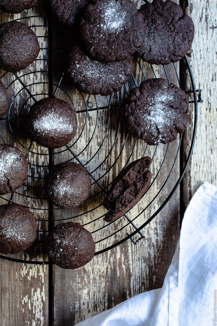 Chocolate Tahini Olive Oil Cookies or Brownies (One Recipe, Two Treats) www.thefoodiecorner.gr Photo description: A close view of some chocolate biscuits/cookies on a cooling rack. One of them has been broken in half, the two pieces leaning against each other – inside part facing up to the camera. 