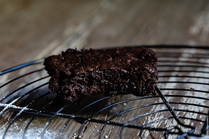 Chocolate Tahini Olive Oil Cookies or Brownies (One Recipe, Two Treats) www.thefoodiecorner.gr Photo description: A close view of a brownie on a cooling rack, the moist sides glistening.