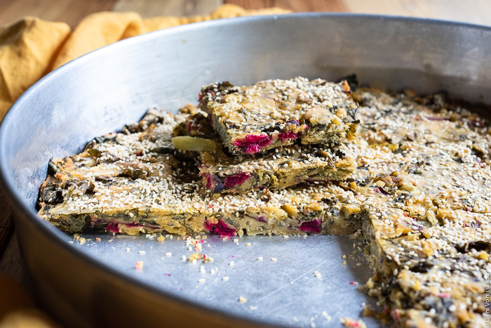 Easy Greek “Flour Pie” with Cornmeal, Spelt and Mixed Greens (Spinach and Beets) www.thefoodiecorner.gr Photo description: A close side view of the pie with some slices removed and placed one on top of the other so as to reveal the pink beetroot stems inside.