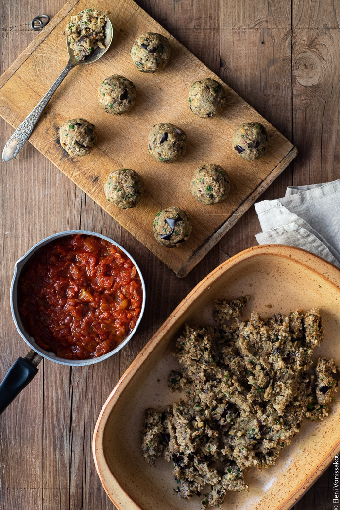 Aubergine (Eggplant) “Meatballs” with Tomato Sauce and Spaghetti www.thefoodiecorner.gr Photo description: A baking dish with aubergine meatball mixture. Next to it is a chopping board with eggplant meatballs on it and a small pot of tomato sauce.