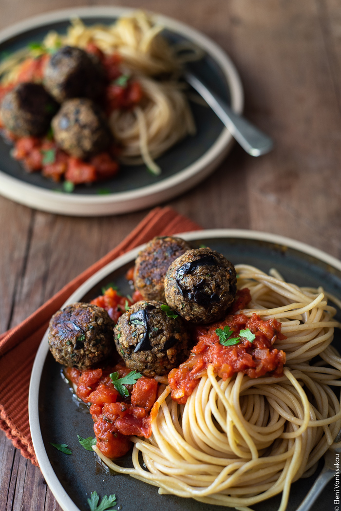 Aubergine (Eggplant) “Meatballs” with Tomato Sauce and Spaghetti www.thefoodiecorner.gr Photo description: A close view of a plate with spaghetti and eggplant meatballs. In the background, half visible is a second plate.