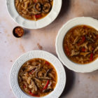 Slow Cooker Hot and Sour Cabbage Soup with Shiitake Mushrooms www.thefoodiecorner.gr Photo description: Three bowls of soup on a marble surface. At the side of one is a tiny bowl with chilli flakes.