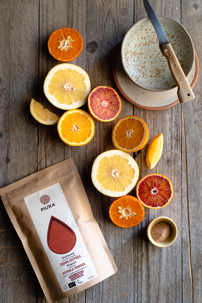 Acerola and Coconut Yoghurt Citrus Fruit Platter www.thefoodiecorner.gr Photo description: Some halved citrus fruit arranged on a distressed wooden surface. To the top right a small empty ceramic bowl with a knife lying over the top. To the bottom left is a packet of acerola.