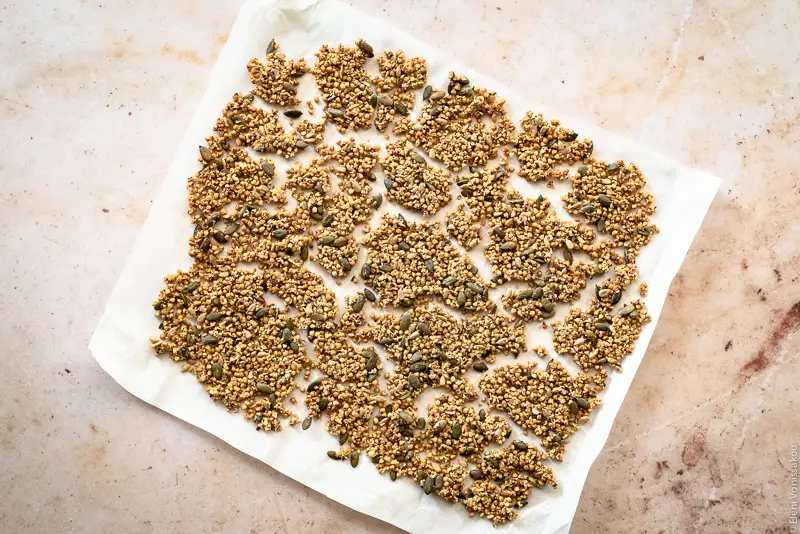 Leafy Green Salad with Blueberries and Savoury Buckwheat Granola www.thefoodiecorner.gr Photo description: Baked granola on a piece of baking paper.