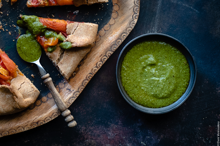 Dips with Leftover Herbs and an Article on Food Waste www.thefoodiecorner.gr Photo description: A small bowl with a vibrant green dressing made with basil. To the left a piece of galette with a spoon full of vinaigrette lying next to it.