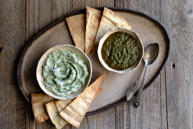 Dips with Leftover Herbs and an Article on Food Waste www.thefoodiecorner.gr Photo description: a ceramic platter with two small bowls of dips on it. Around the bowls are some homemade pitta chips.