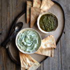 Dips with Leftover Herbs and an Article on Food Waste www.thefoodiecorner.gr Photo description: a ceramic platter with two small bowls of dips on it. Around the bowls are some homemade pitta chips.