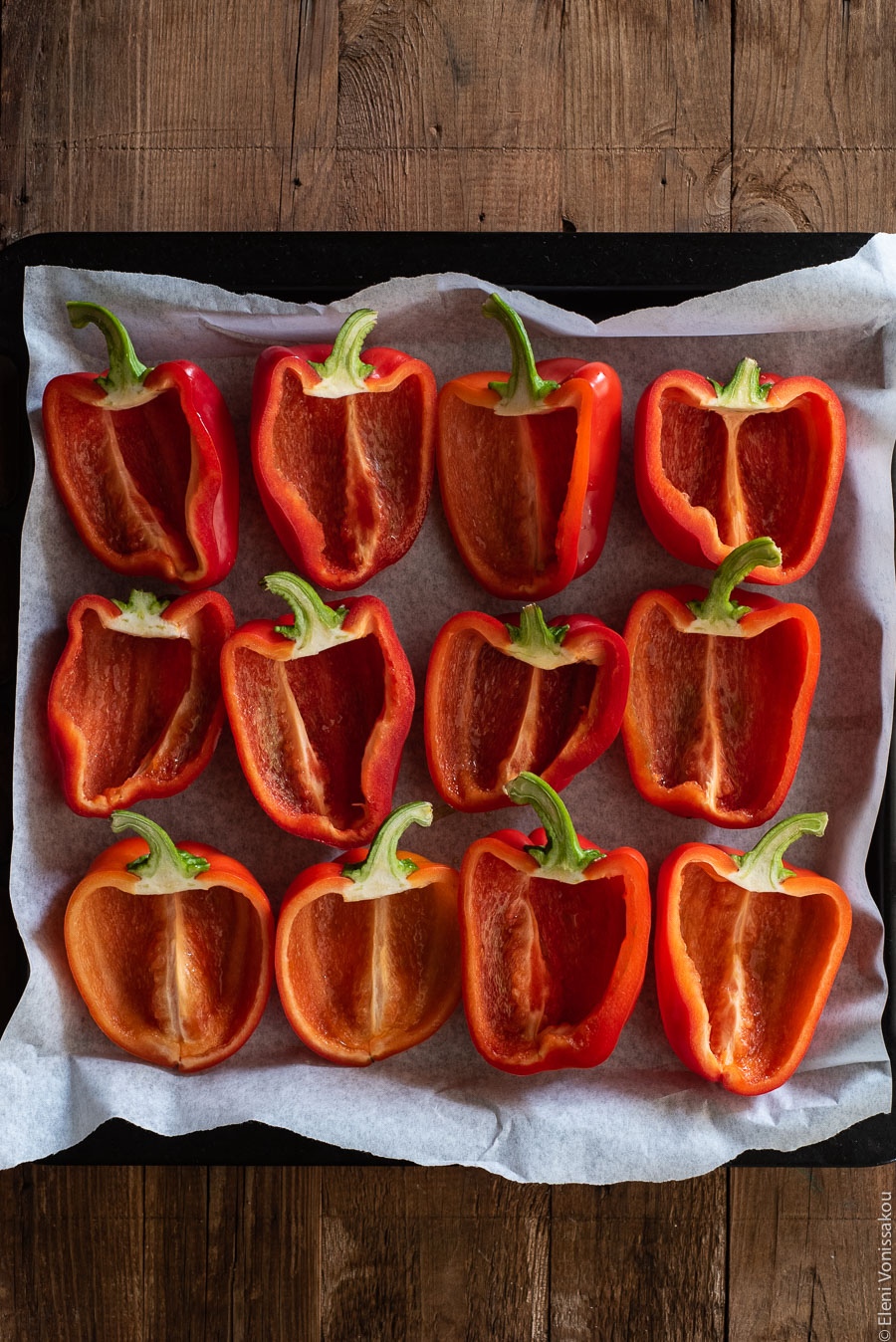 Roasted Red Peppers Stuffed with Mushroom, Pumpkin and Harissa Chickpea Orzotto www.thefoodiecorner.gr Photo description: a baking tray lined with grease proof paper and filled with red pepper halves.